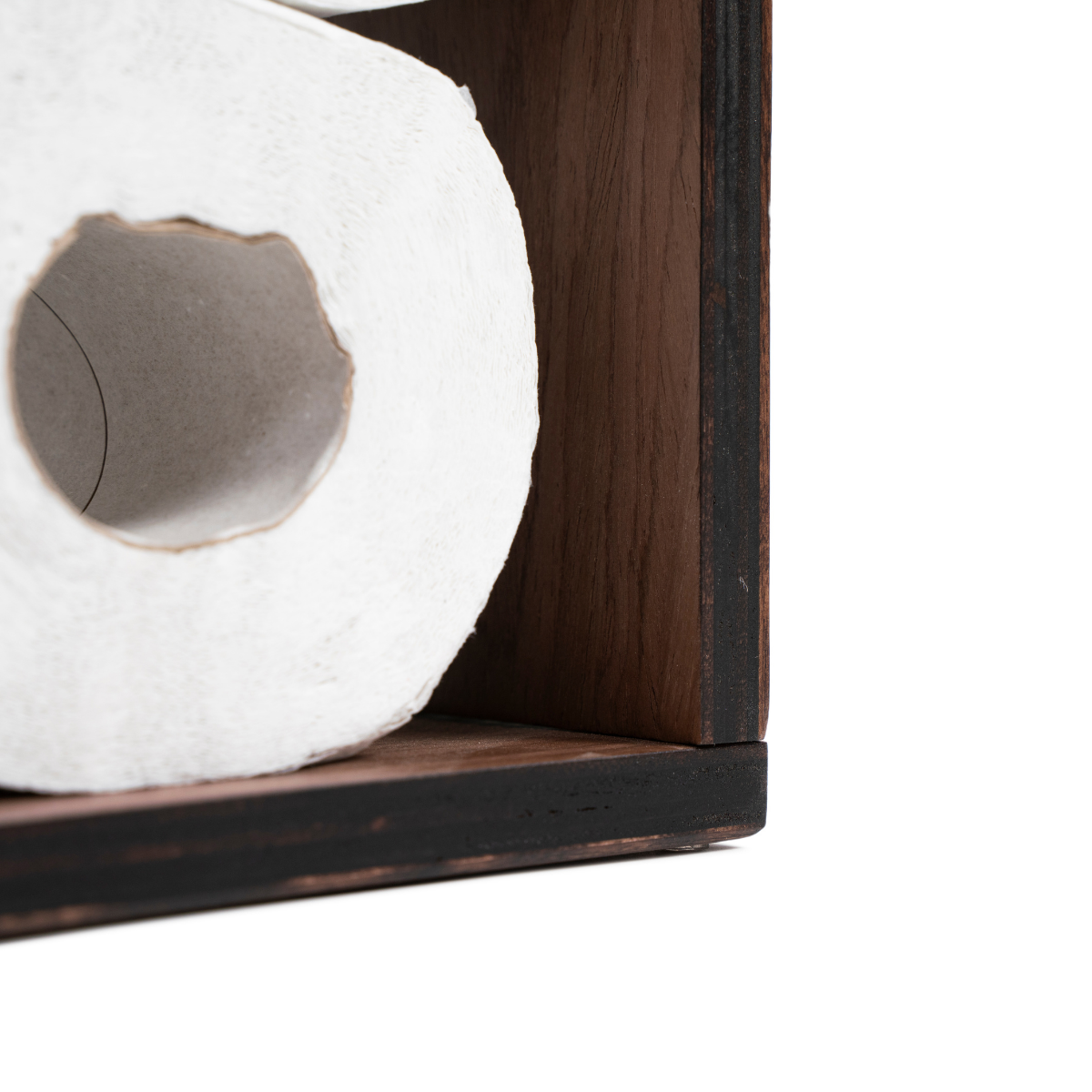 Close-up of a dark walnut veneer toilet paper holder with stained edges, showing a roll of toilet paper stored inside the unit.