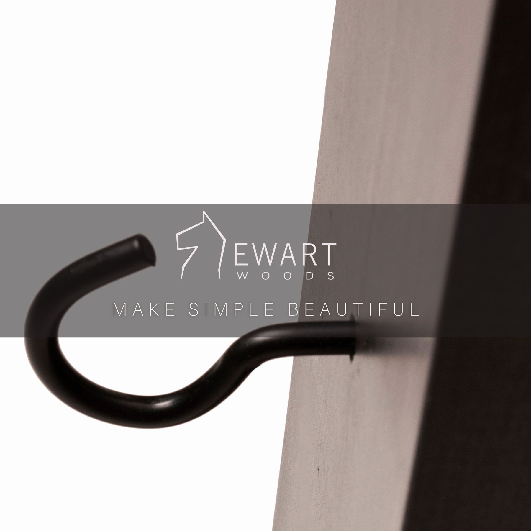Close-up of a metal hook on a dark-stained wooden mug holder with the EWART WOODS logo and slogan &