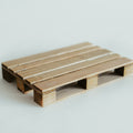 Handcrafted wooden pallet coaster in a natural stained finish, showcasing smooth texture and precise detailing, placed on a light surface.
