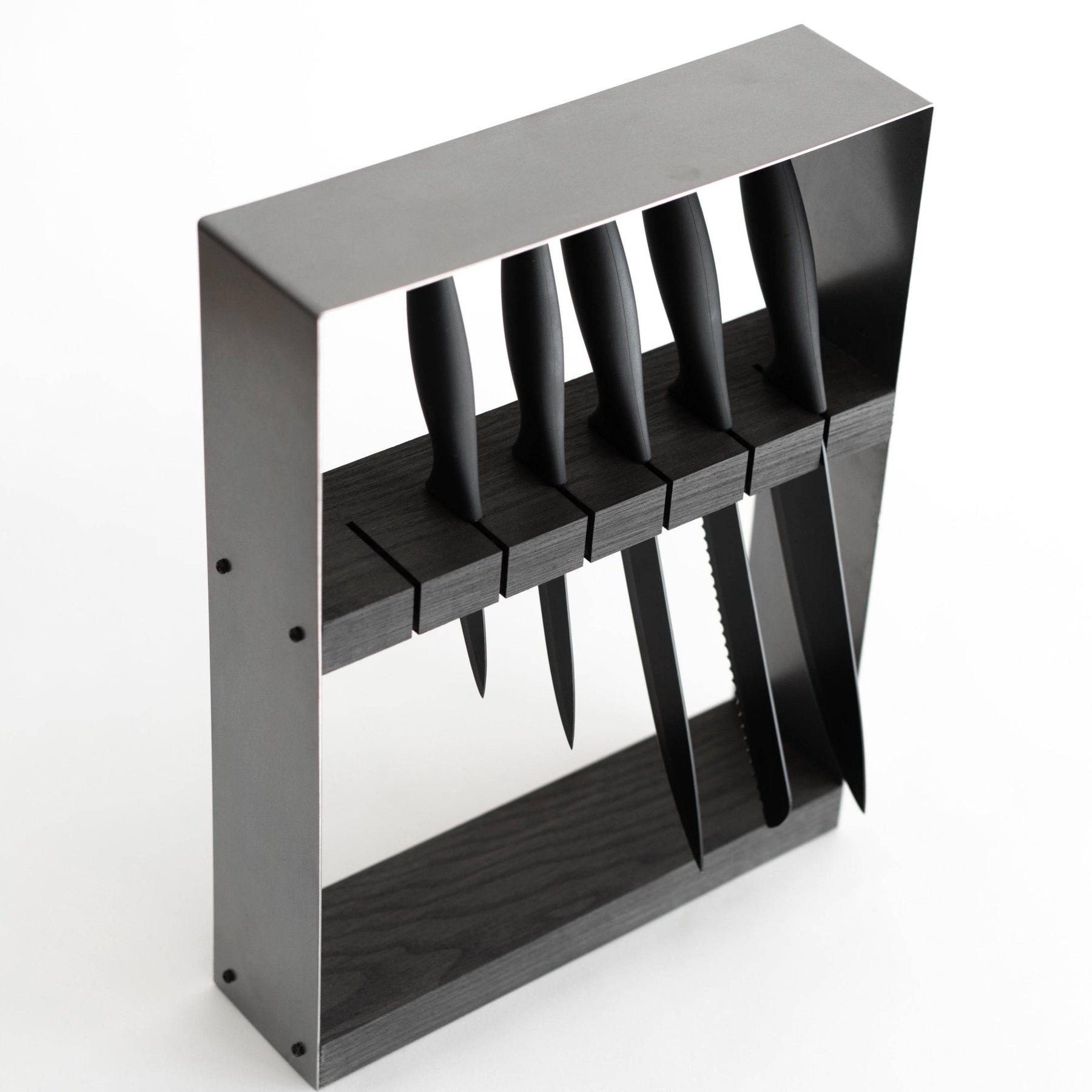 Close-up of a modern knife organizer with a dark wooden block, securing multiple black-handled knives horizontally in precision-cut slots.
