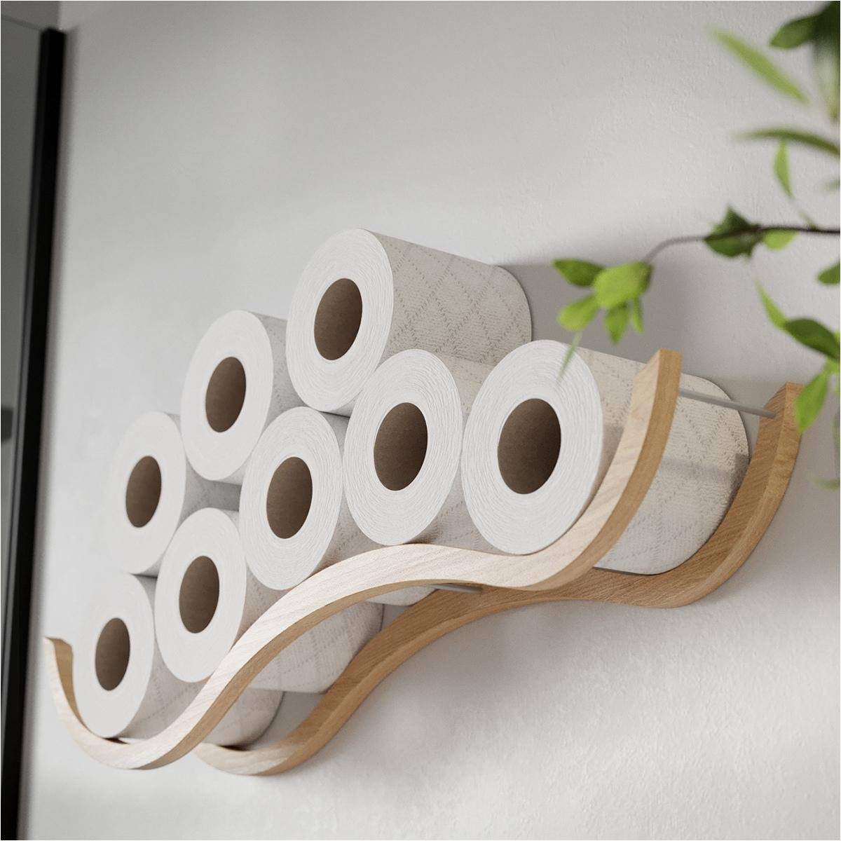 Wall-mounted wooden holder with a wave design, storing multiple rolls of toilet paper, with green plant leaves in the background.