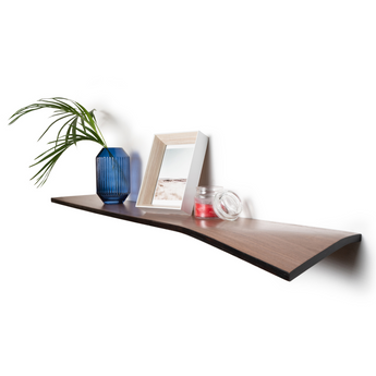 Wooden wall shelf with a curved, beveled edge, holding a blue vase, a framed photo, and a small glass jar. The shelf features a dark wood finish.