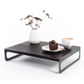 Elegant wooden serving tray with a black finish, featuring sleek metal legs. The tray is adorned with a white vase of dried flowers, a plate with a slice of cake, and a cup of coffee, all arranged neatly.