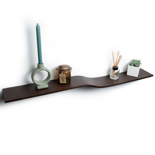 Thin, dark wooden floating shelf with a curve in the middle, holding decor items. The shelf has a stained edge and a modern look.