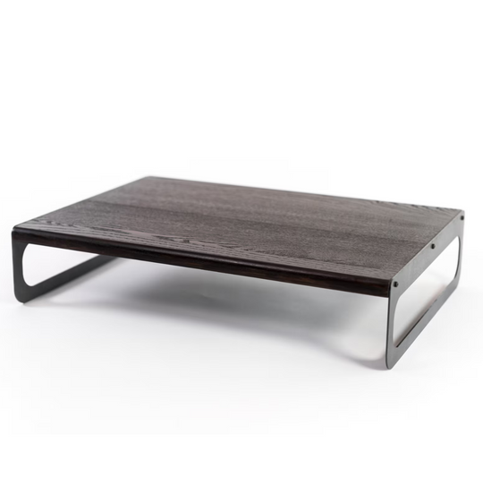 Wooden serving tray with a dark ash finish, showcasing a smooth yet textured surface and sleek metal handles, all in a minimalist design.