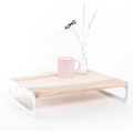 Wooden serving tray with a light ash finish, featuring sleek white metal handles. The tray is styled with a pink cup and a small vase with dried flowers, showcasing a clean, minimalist design.