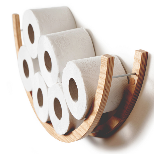 Side view of a wooden half-circle toilet paper holder, displaying seven rolls of toilet paper. The holder is made of light wood with a smooth texture, featuring metal bars for support.