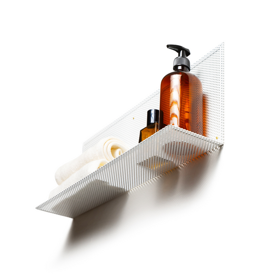Wall-mounted perforated metal shelf designed for minimalist storage, perfect for towels and bottles in modern spaces.