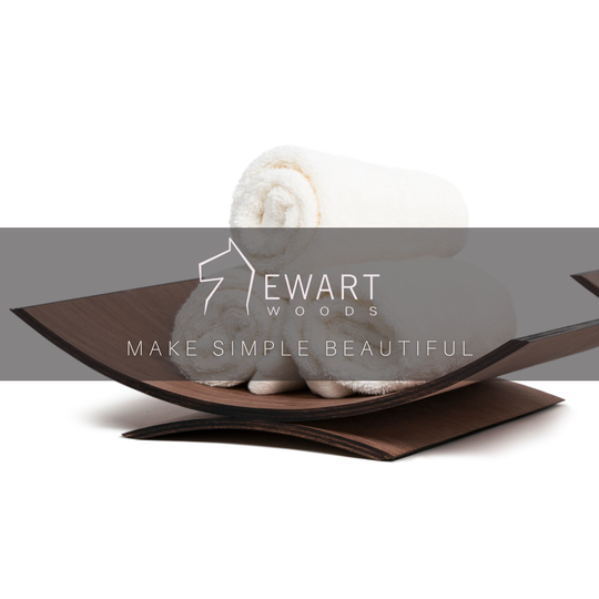Curved wooden holder with rolled white towels and the Ewart Woods logo overlay with the tagline &
