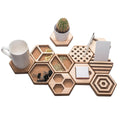 Geometric wooden desk organizers in hexagon shapes, holding a coffee mug, a small cactus, various clips, sticky notes, and a pen, all arranged on a white background.
