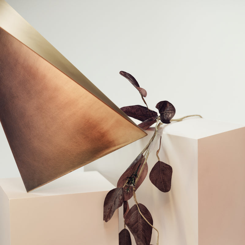 Close-up detail of brass geometric wall shelf triangular metal floating shelf