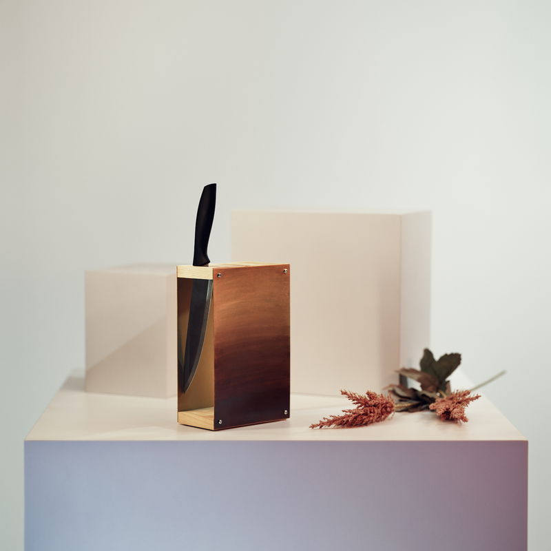 Knife block with gold painted metal and wooden slots for knives 