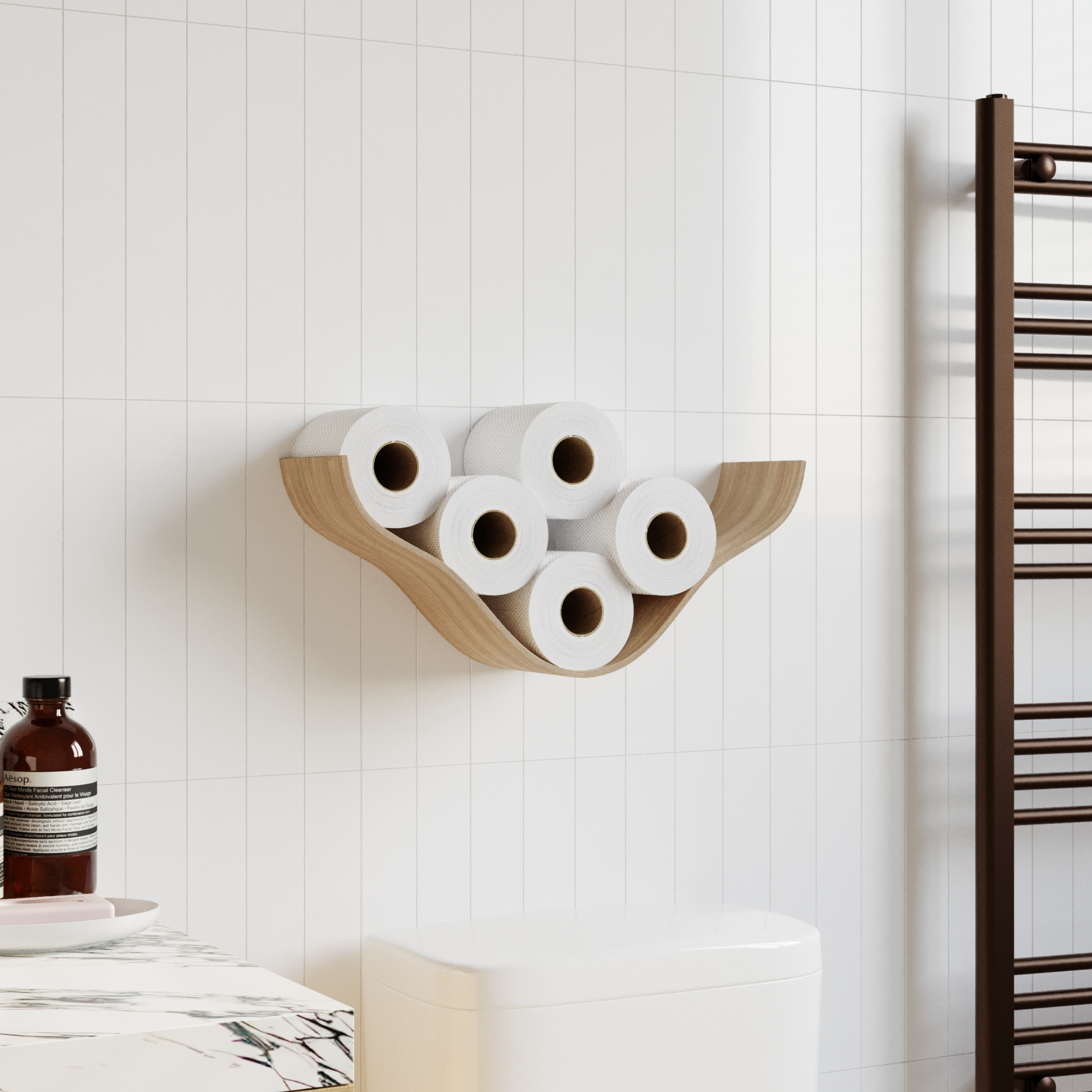 Wooden wall shelf with a cloud-like, curved design holding five rolls of toilet paper, mounted on white tiled walls in a modern bathroom next to a toilet and towel rack.