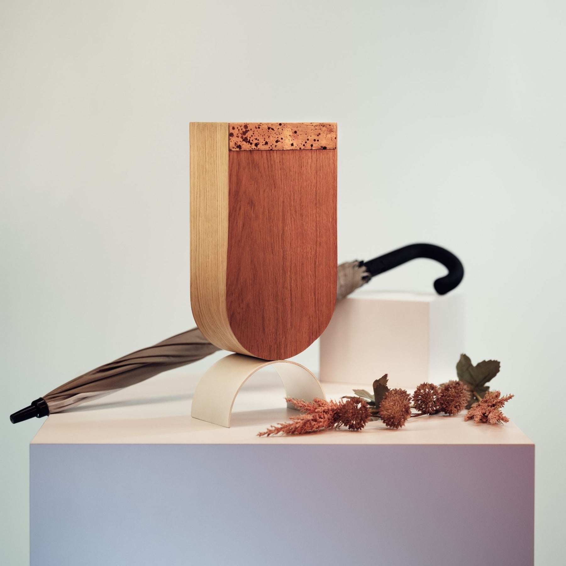 Wooden free standing umbrella holder with brass design and white curved metal leg 