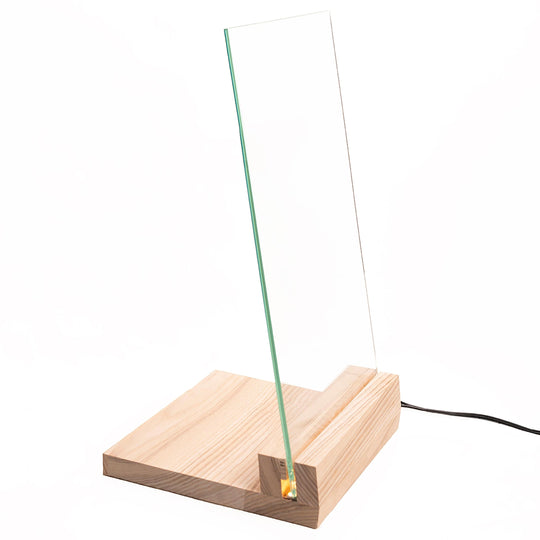 A clear acrylic panel inserted into a light wood base with a small built-in LED light, connected by a black power cord, displayed against a white background.