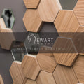 Close-up of hexagonal wooden tiles and mirror pieces arranged on a gray wall, featuring the Ewart Woods logo with the tagline &