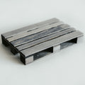 Handcrafted wooden pallet coaster in a gray-stained finish, featuring a smooth texture and detailed craftsmanship, displayed on a light surface.