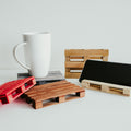 Different color variations for handmade wooden pallet coasters featuring smooth, polished slats and carefully crafted details, resting on a white surface.