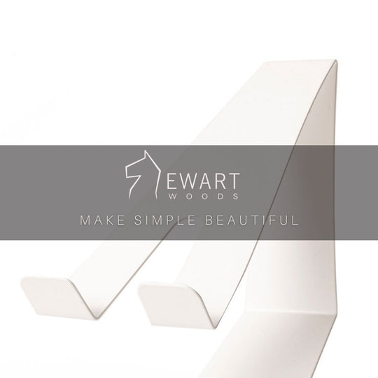 A sleek white minimalist phone holder shown from a side angle, with the Ewart Woods logo and the slogan &
