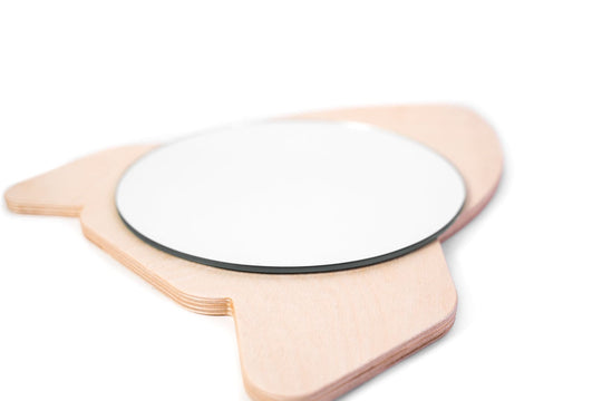Side view of a rocket-shaped wooden mirror with a round reflective surface, showcasing the layered wood and smooth finish.