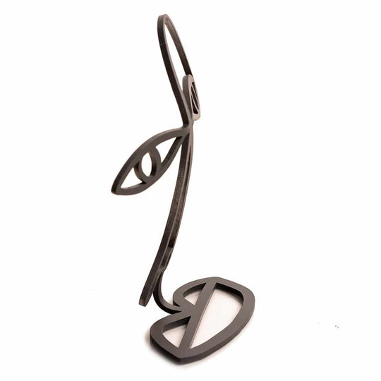 Side view of an abstract black metal glasses stand shaped like a minimalist face, featuring an eye, nose, and lips in a wireframe design.