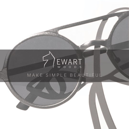 Close-up of a black metal abstract glasses holder with sunglasses placed over the eyes. The &