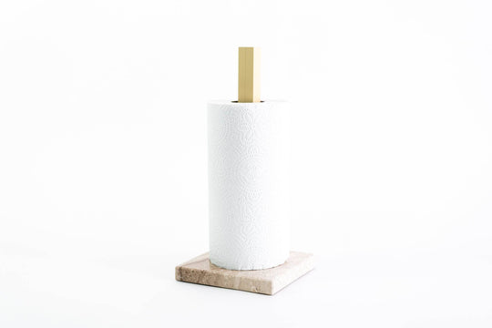 Paper towel holder with a beige marble base and gold metal stand, holding a white paper towel roll, designed for a sleek and sophisticated look.