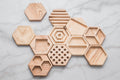 Hexagonal wooden desk organizers arranged in a modular layout on a marble surface.