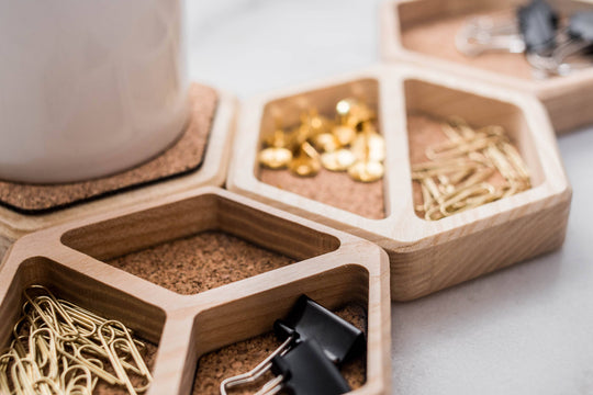 Cork inlay organizers with hexagonal wooden compartments, designed to neatly hold paper clips, thumbtacks, and binder clips, adding both functionality and style to your workspace.