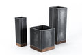 Set of three black metal utensil holders with wooden bases in different heights, in an industrial style.