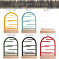 Jewelry holders available in six color variations: yellow, blue, white, green, black, and red. Each holder features an arched frame with horizontal bars, made from durable steel and set on a wooden base.