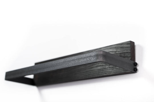 Modern black metal towel rack with a dark wood base, featuring a clean and geometric design.