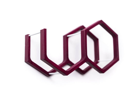 Close-up of a wall-mounted purple mini honeycomb toilet paper holder. The holder features a textured wood surface, highlighting the natural grain in a modern design.