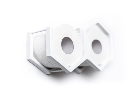 Close-up of a wall-mounted white mini honeycomb toilet paper holder, displaying two rolls of toilet paper. The holder features a textured wood surface, highlighting the natural grain in a modern design.