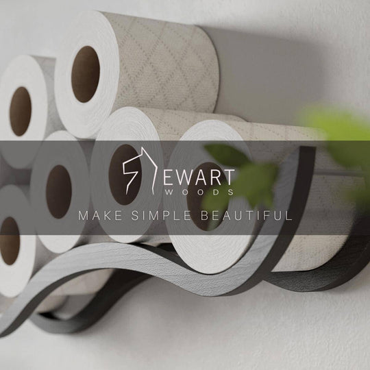 Close-up of a wall-mounted wave design wooden toilet paper holder, displaying several rolls. The EWART WOODS logo and the slogan MAKE SIMPLE BEAUTIFUL are overlaid on the image.
